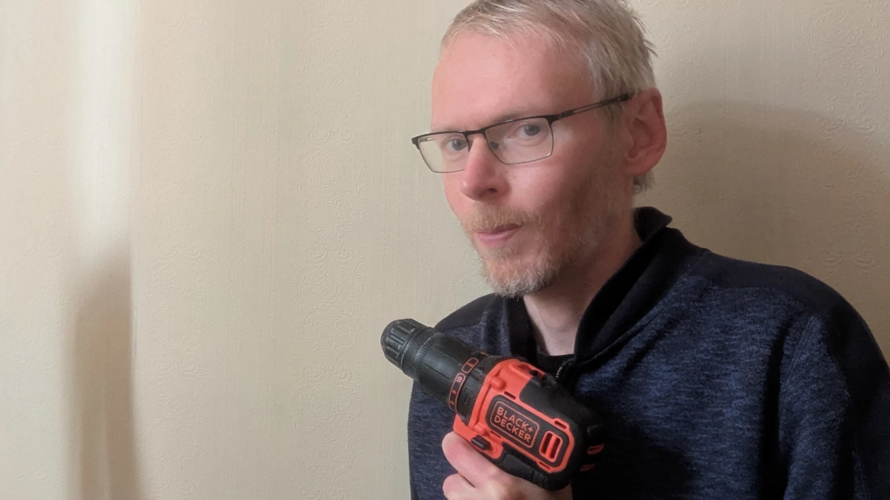 Handyman using a power drill on shelving